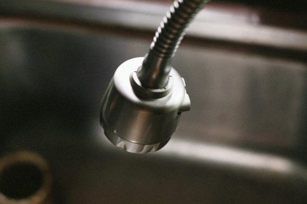 Moderni virtuvės kriauklė su švariu sifonu po ja, užkertantis kelią nemaloniems kvapams.