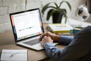 Verslo specialistas analizuojantis naujienlaiškių statistiką ir bendraujantis su auditorija per nešiojamąjį kompiuterį.