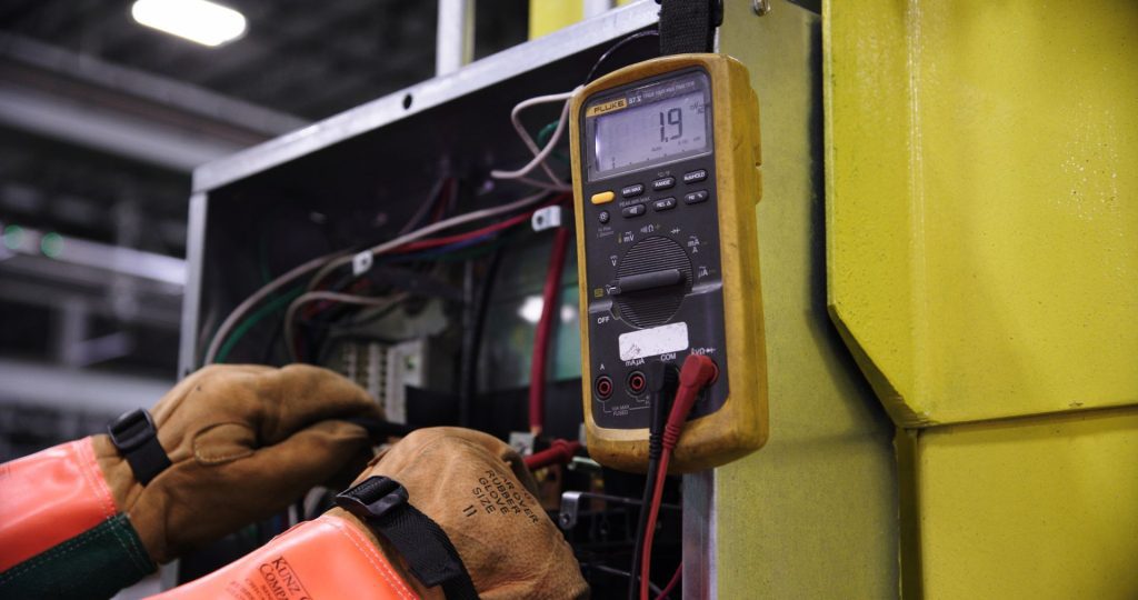 Elektrikas tikrina elektros skydą po ilgos pastato prastovos