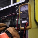 Elektrikas tikrina elektros skydą po ilgos pastato prastovos