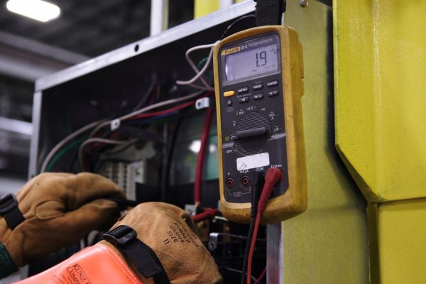 Elektrikas tikrina elektros skydą po ilgos pastato prastovos