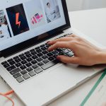 SEO specialistas analizuoja svetainės duomenis ir optimizavimo strategiją kompiuterio ekrane.