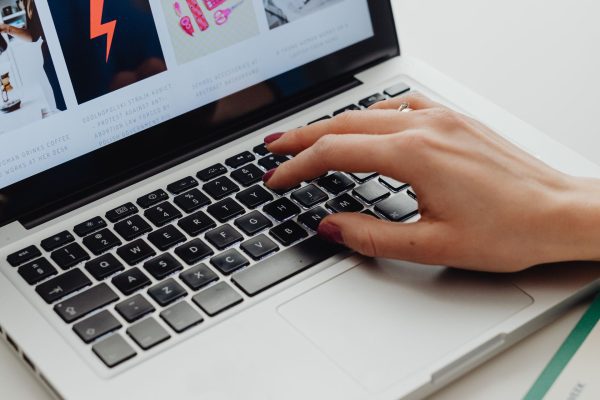SEO specialistas analizuoja svetainės duomenis ir optimizavimo strategiją kompiuterio ekrane.
